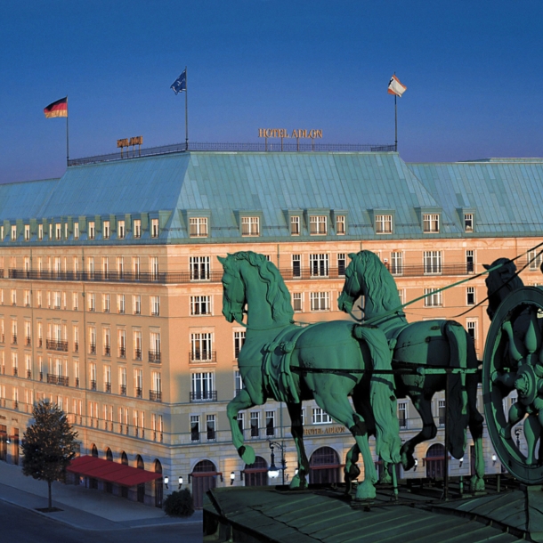 Luftaufnahme der Außenfassade des Hotel Adlon am Pariser Platz mit der Quadriga am Brandenburger Tor im Vordergrund.