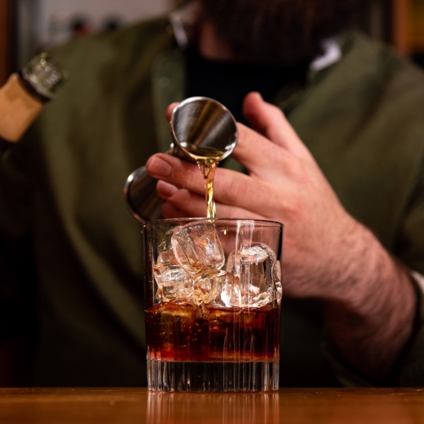 Ein Barkeeper gießt ein Glas Whisky ein.