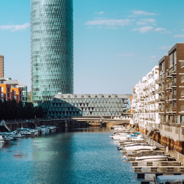 Binnenhafen mit Booten vor Wohnhäusern und einem modernen Gebäudekomplex.