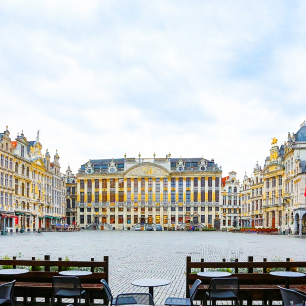 Grand Place in Brüssel mit Tischen und Stühlen im Vordergrund.