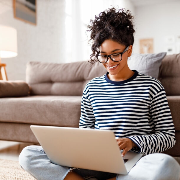 gut gelaunte Frau sitzt zuhause am Laptop