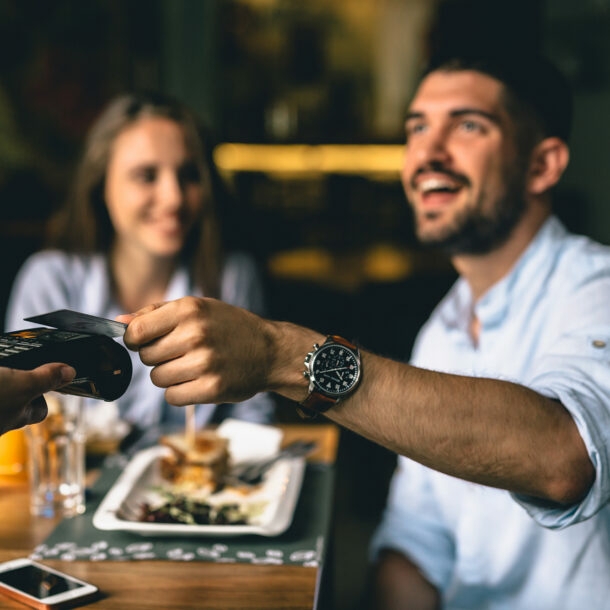 Junges Paar im Restaurant bezahlt mit Kreditkarte