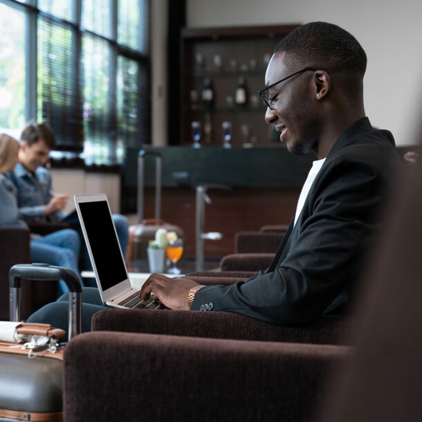 Geschäftsmann arbeitet in Hotellobby am Laptop