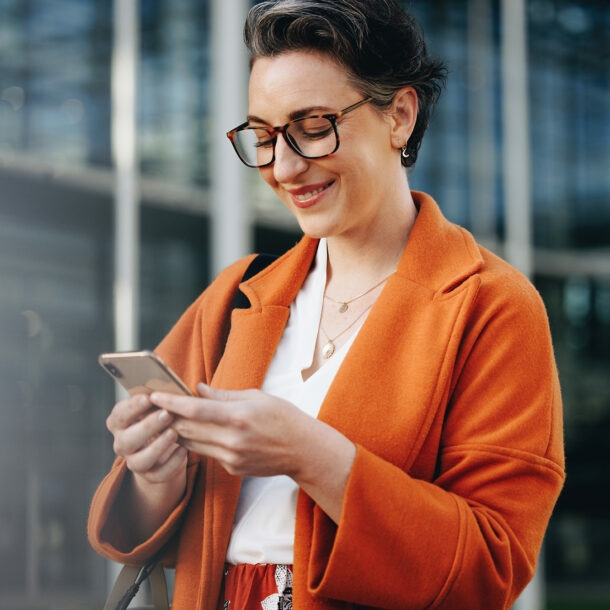 Elegante Geschäftsfrau schaut auf ihr Smartphone