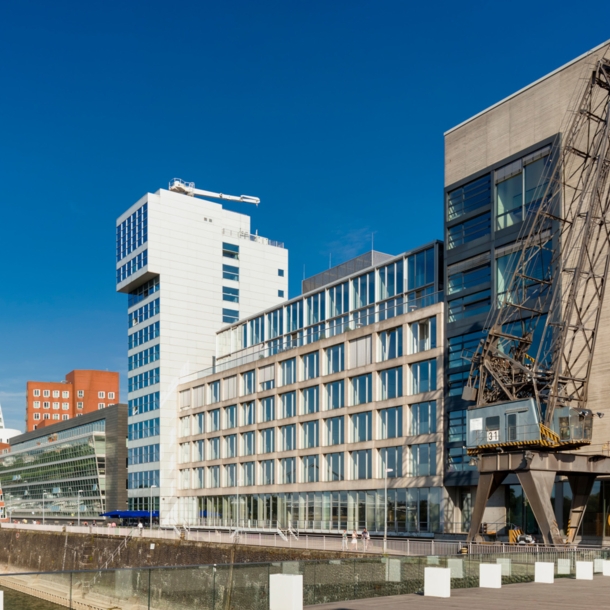 Verschiedene Gebäude mit Kran am Düsseldorfer Binnenhafen, Hintergrund ein Fernsehturm.