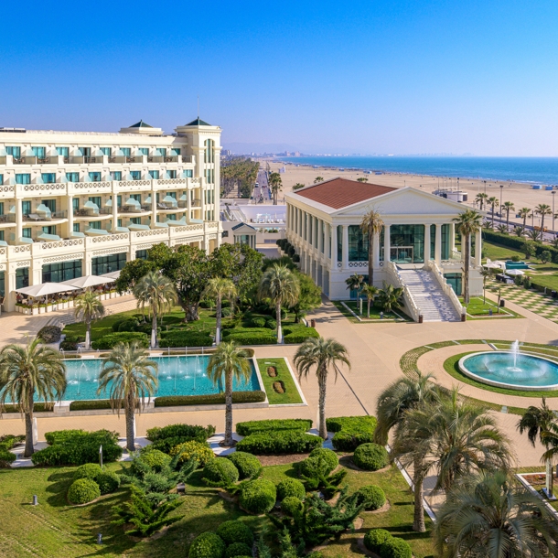 Luxuriöse Hotelanlage mit Pools und Palmengarten an einem breiten Sandstrand.