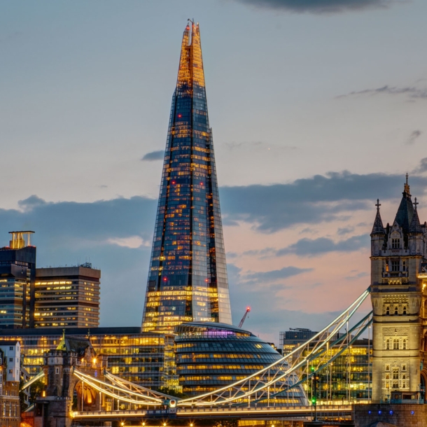 Beleuchtete Londoner Skyline mit Wolkenkratzer The Shard und Tower Bridge am Abend.