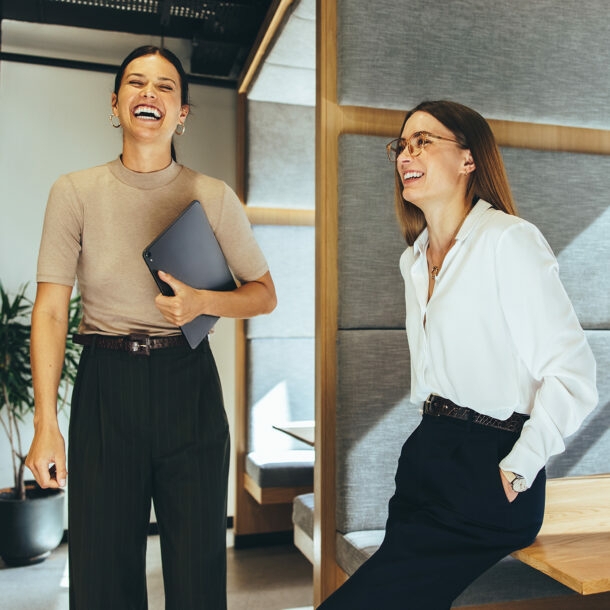 Zwei junge Geschäftsfrauen lachen im Büro