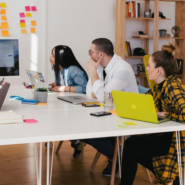 Junges Team arbeitet gemeinsam und schaut auf geteilten Bildschirm