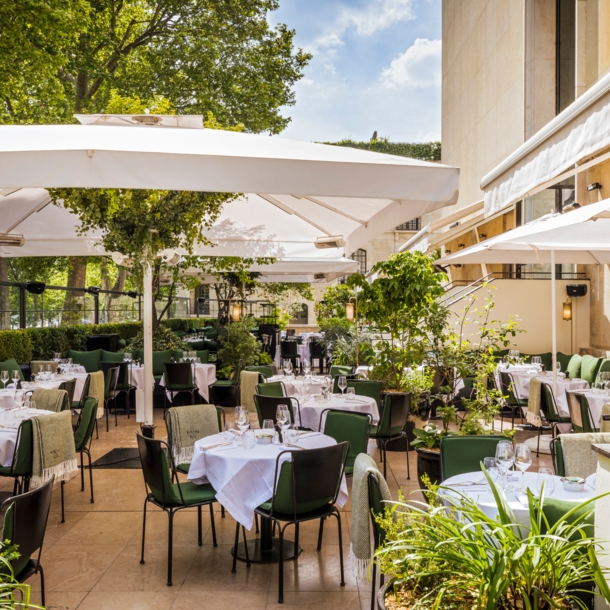 Terrasse eines gehobenen Restaurants mit eingedeckten Tischen.