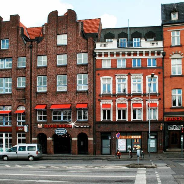 Häuserfront mit Giebelhäusern aus Rotsteinklinker mit Block House Schriftzug.