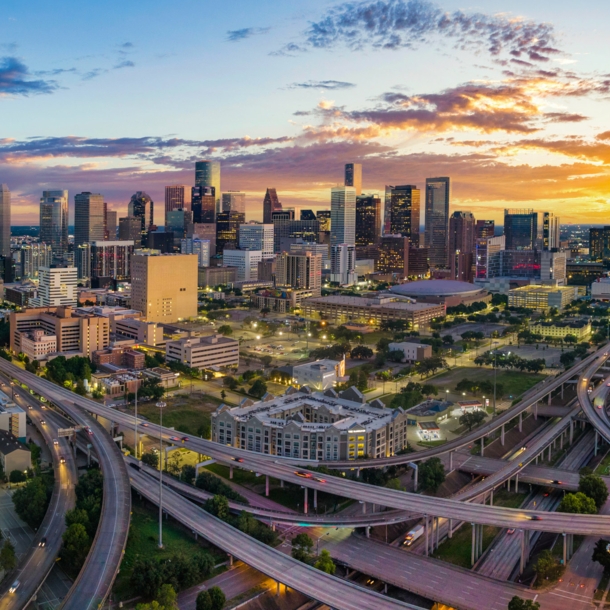 Skyline von Houston mit Autobahnkreuz bei Sonnenuntergang.