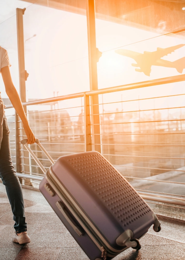 Frau zieht Koffer durch den Flughafen