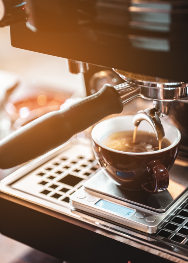 Espresso fließt aus einer Maschine in eine Tasse