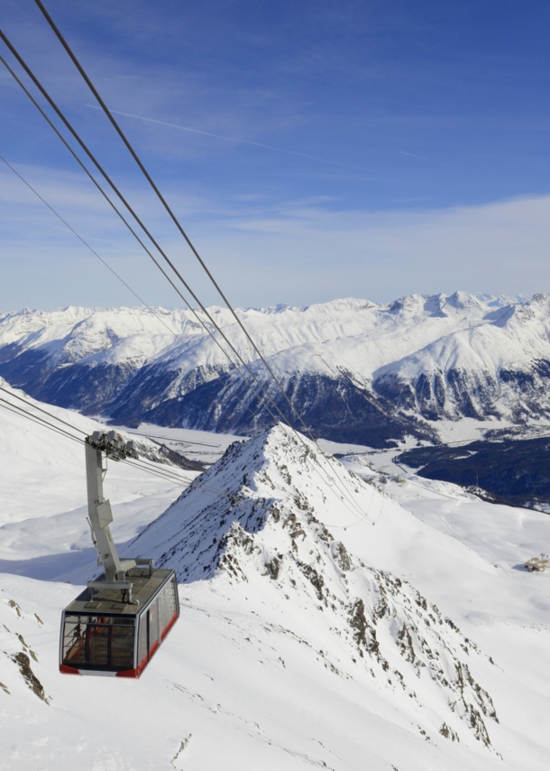 Eine Seilbahn fährt über ein bergiges Skigebiet bei St. Moritz.