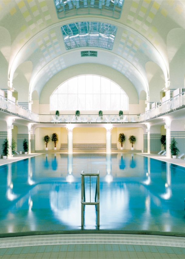 Großes Schwimmbecken in einer im Jugendstil erbauten Badeanstalt mit weißem Kuppeldach