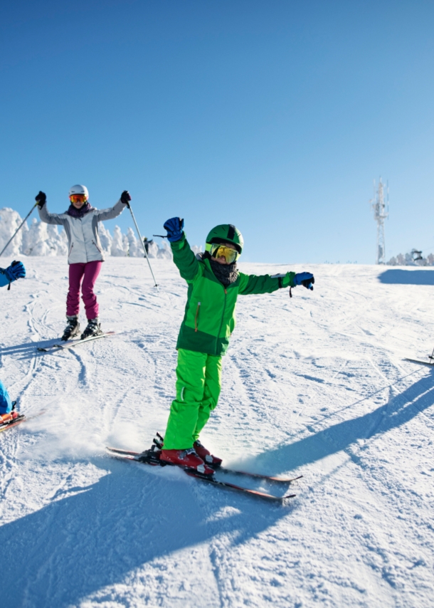 Eine Familie fährt gemeinsam Ski auf der Piste