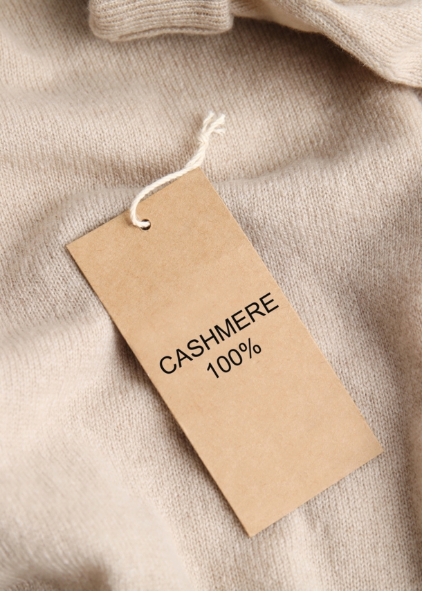 Ein Kaschmir-Pullover mit Etikett, auf dem „Cashmere 100 %” steht.