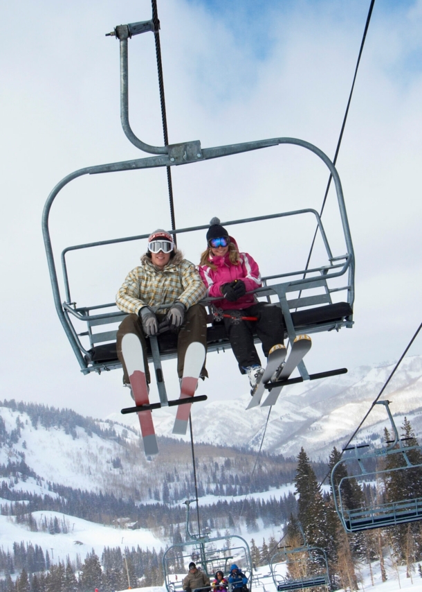 Ein Paar in Skikleidung fährt mit dem Skilift