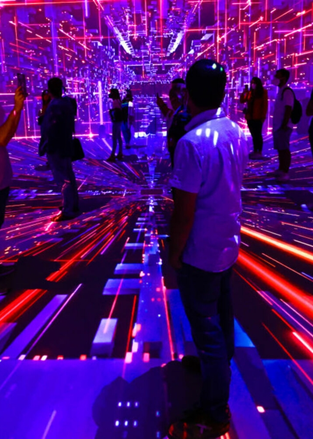 Messebesucher in Barcelona in einem Raum voller roter und blauer Lichtstrahlen