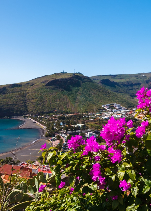 Blick auf die Bucht von Playa de Santiago mit pinken Blumen im Vordergrund