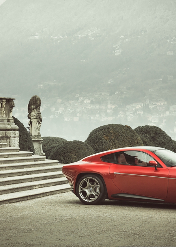 Ein rotes Auto vor der Treppe eines herrschaftlichen Hauses