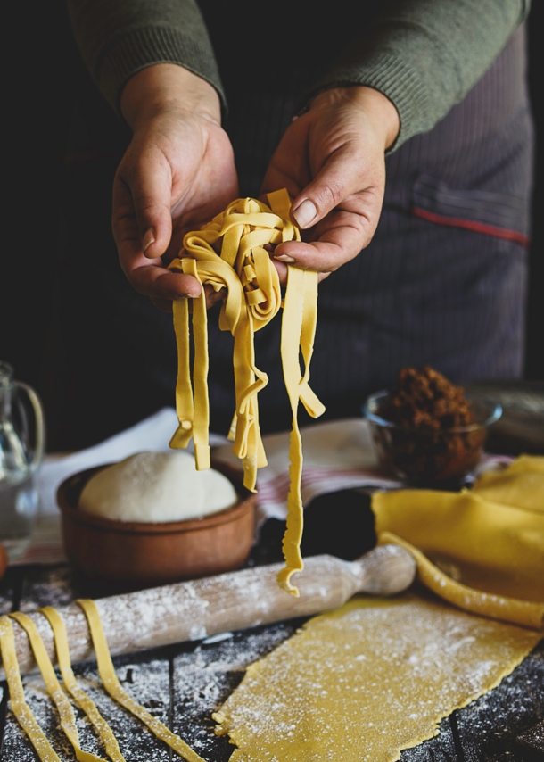 Eine Person hält selbstgemachte Pasta in die Kamera