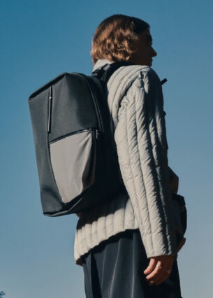 Von hinten fotografierte Person in Jacke und mit Rucksack des Labels côte&ciel