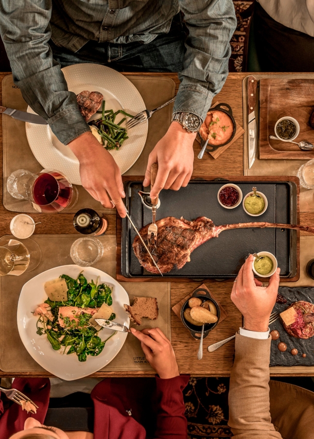 Top-Shot auf einen üppig gedeckten Tisch, an dem mehrere Personen sitzen und essen.