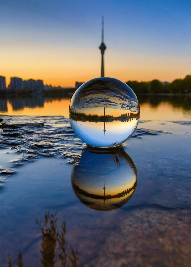 Skyline einer Stadt durch eine Glaskugel im Sonnenuntergang fotografiert