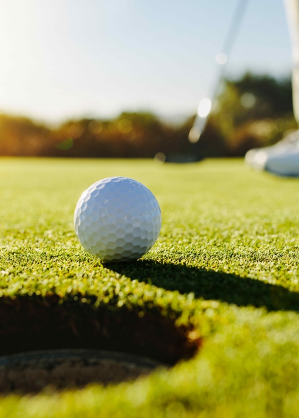 Nahaufnahme eines Golfballs vor dem Loch auf einem Putting-Green