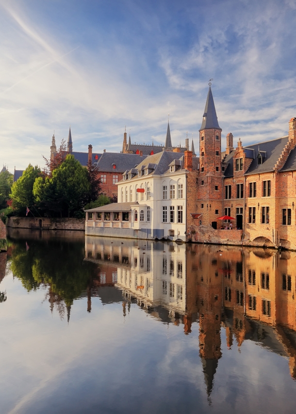 Historisches Zentrum von Brügge mit mittelalterlichen Gebäuden, die sich im Wasser spiegeln.