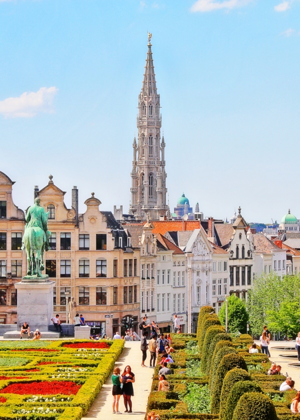 Blick auf symmetrisch angelegten Garten, dahinter historische Häuserfassaden und eine Kirche