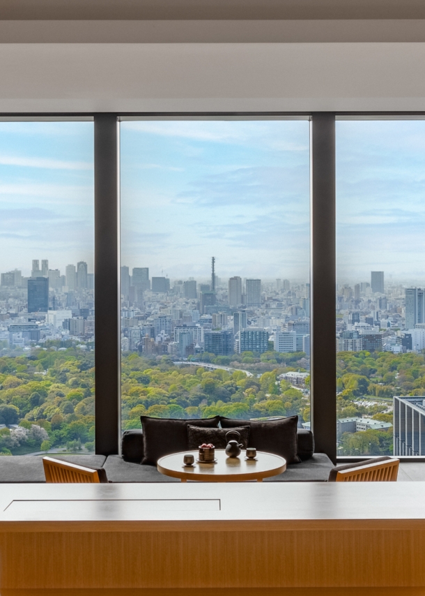 Hotelsuite im japanischen Stil mit Blick durch ein bodentiefes Panoramafenster auf die Skyline von Tokio