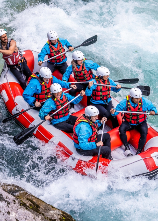 Acht Personen beim Wildwasser-Rafting in einem Schlauchboot