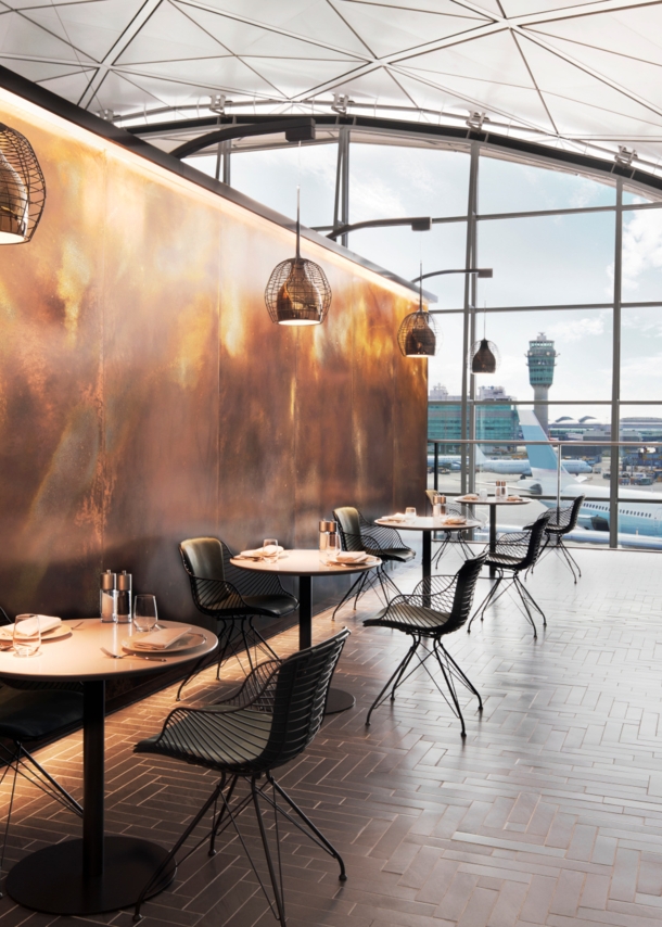 Modernes, edles Restaurant mit eingedeckten Tischen in einem Flughafen mit Panoramablick aufs Rollfeld