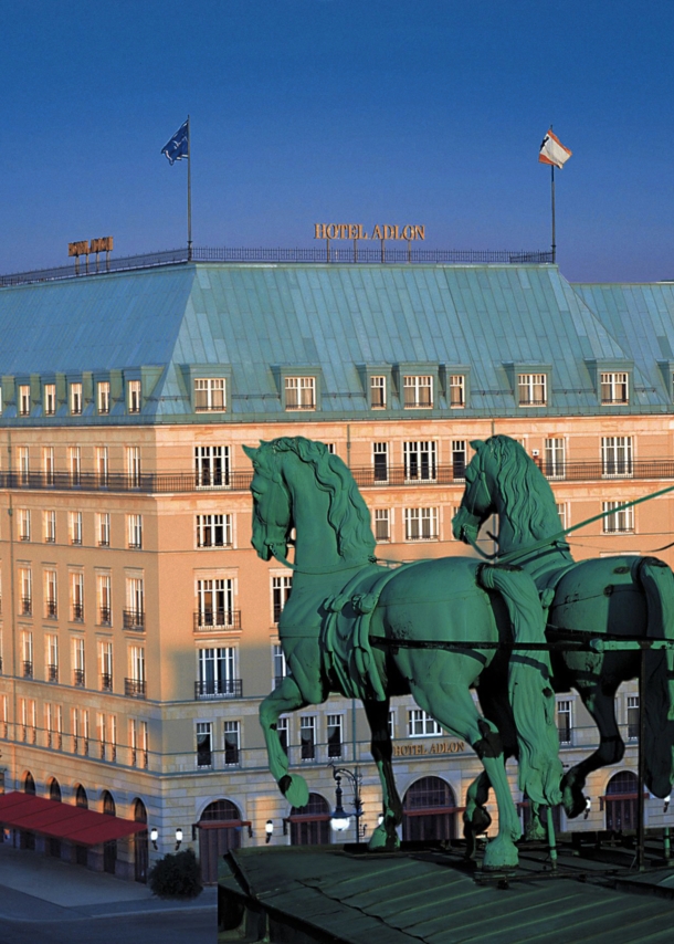 Luftaufnahme der Außenfassade des Hotel Adlon am Pariser Platz mit der Quadriga am Brandenburger Tor im Vordergrund.