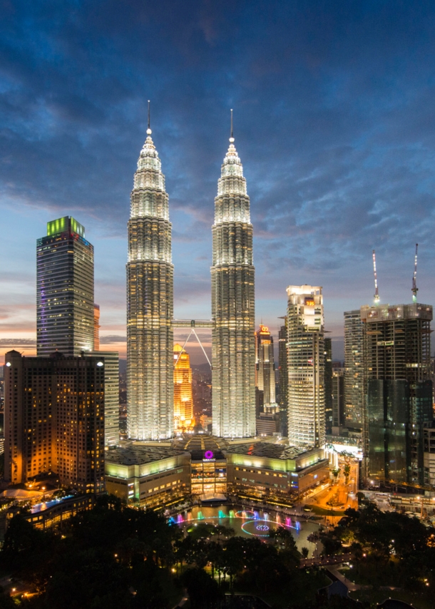 Nachtaufnahme der erleuchteten Skyline der City von Kuala Lumpur mit den Petrona Twin Towers im Mittelpunkt.