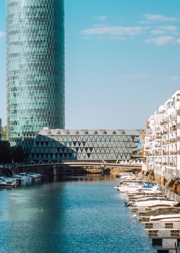 Binnenhafen mit Booten vor Wohnhäusern und einem modernen Gebäudekomplex.