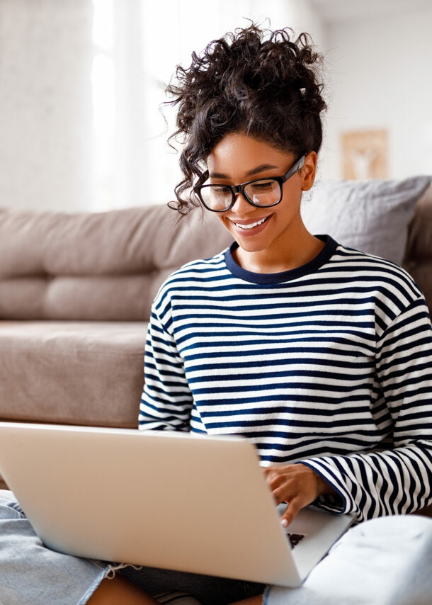 gut gelaunte Frau sitzt zuhause am Laptop