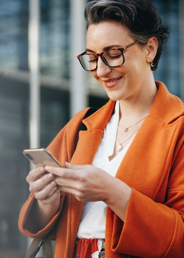 Elegante Geschäftsfrau schaut auf ihr Smartphone