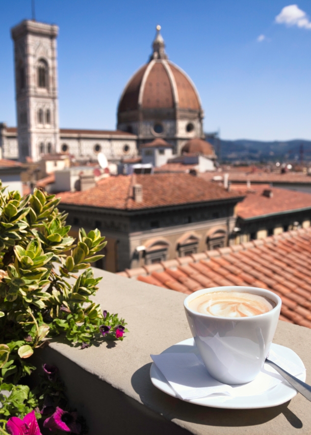 Stadtpanorama von Florenz mit Dom, im Vordergrund eine weiße Cappuccinotasse auf einer Mauer.