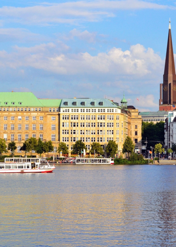 Häuserfront und Promenade am Wasser mit Booten in der Hamburger Altstadt.