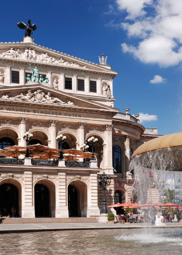 Prachtvolles Operngebäude im Stil der Neorenaissance mit Restaurant, im Vordergrund ein Springbrunnen.