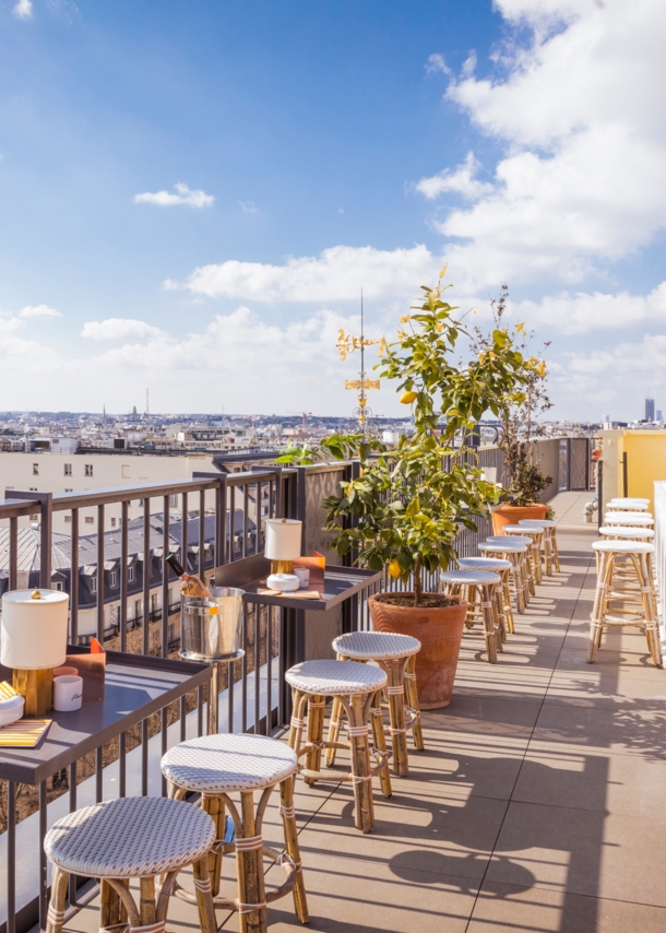 Dachterrasse des Restaurants Perruche mit Blick auf die Dächer von Paris und den Eiffelturm in der Ferne.