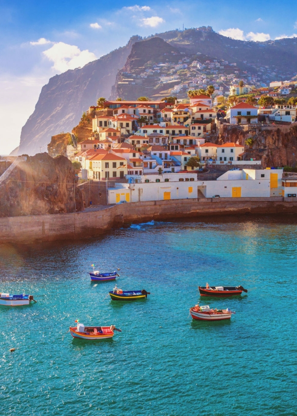 Panorama von Funchal auf Madeira mit Booten im Vordergrund und Bergen im Hintergrund.