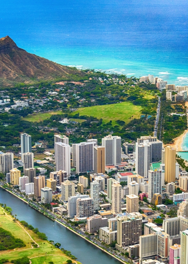 Luftaufnahme von Stadtpanorama von Honolulu mit Hochhäusern am Meer.