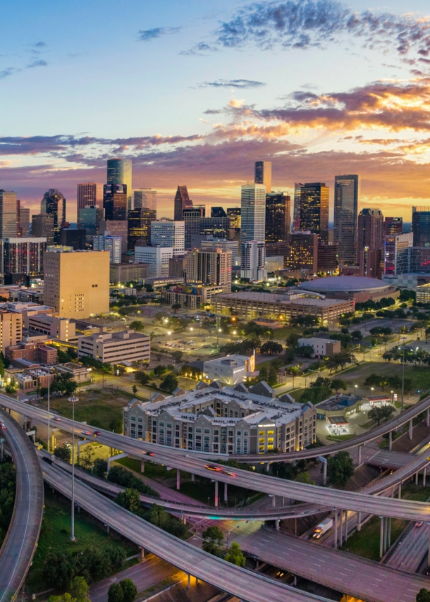 Skyline von Houston mit Autobahnkreuz bei Sonnenuntergang.