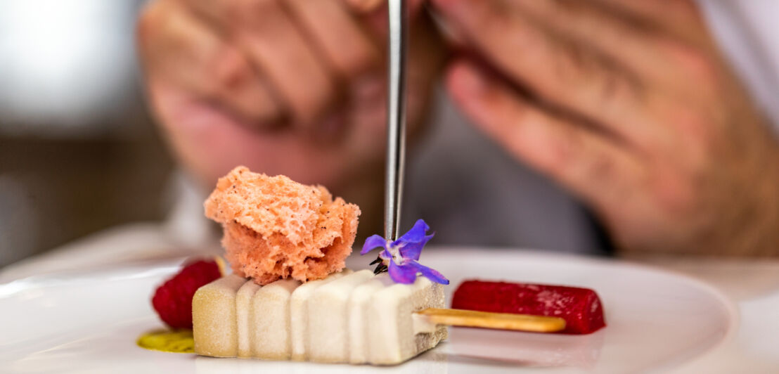 Koch dekoriert Molekularküchen-Dessert mit Blüte