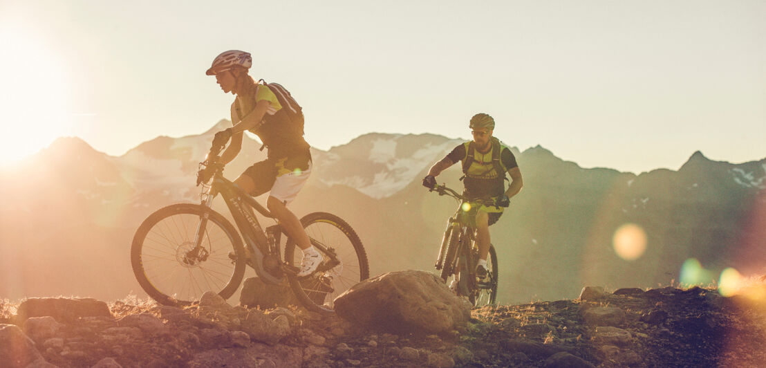 Zwei Personen mit E-Mountainbike auf einem Berggrat